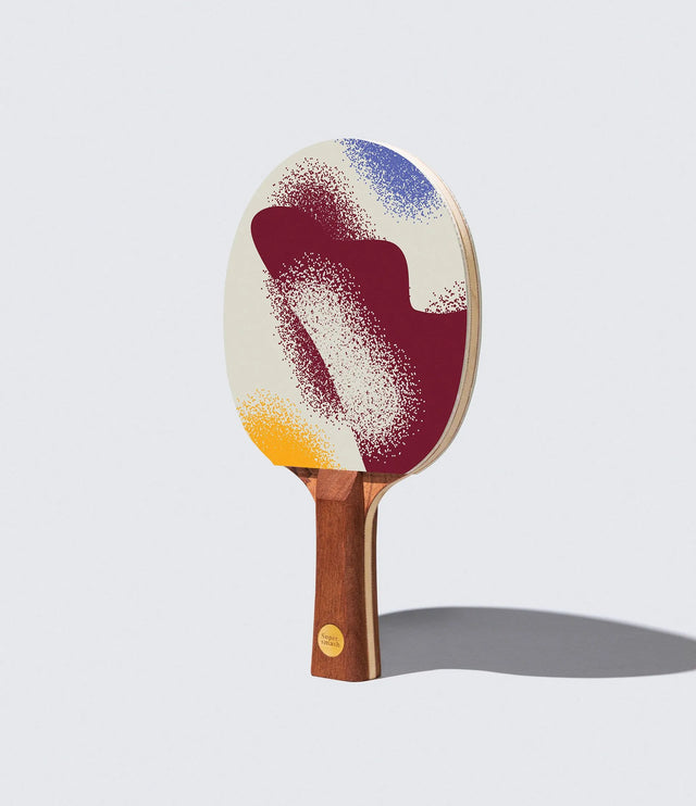 Ping pong paddle with a colorful design on a light gray background