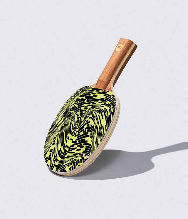 Pickleball paddle with a black and yellow pattern on a light gray background