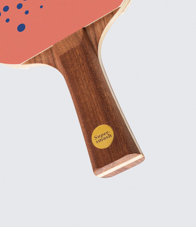Table tennis paddle with wooden handle and pink rubber, featuring 'Super Smash' logo.