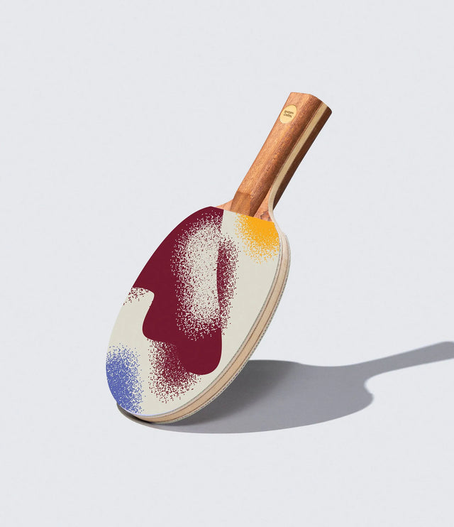 Colorful ping pong paddle on a light gray background