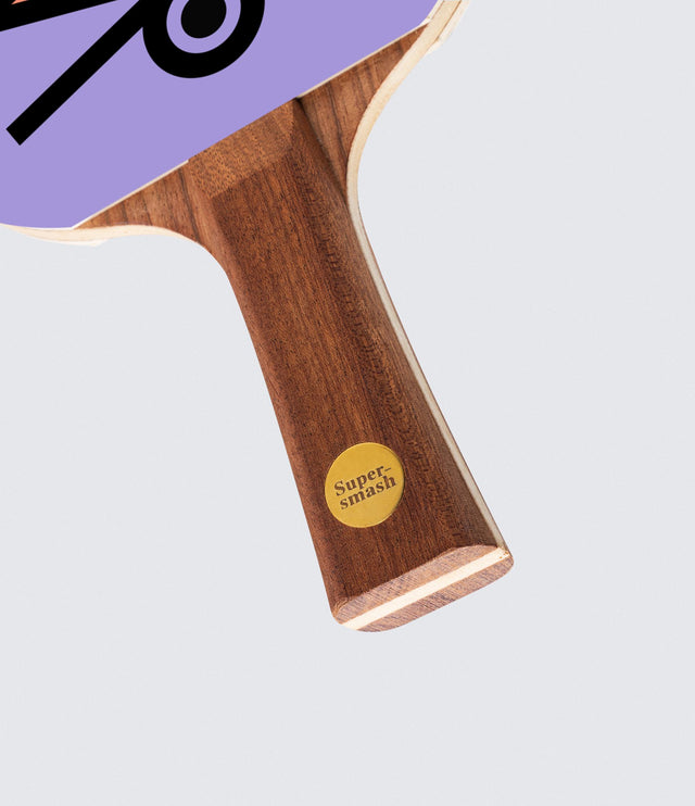 A ping pong paddle with a purple design with a natural wood handle.