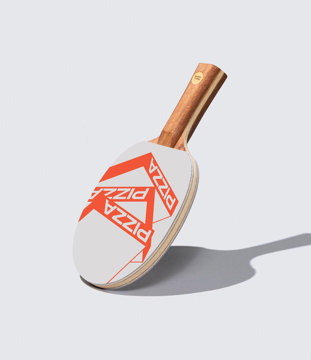 A ping pong paddle with a white and orange 'Pizza' brand design on the paddle's surface, with a wooden handle.